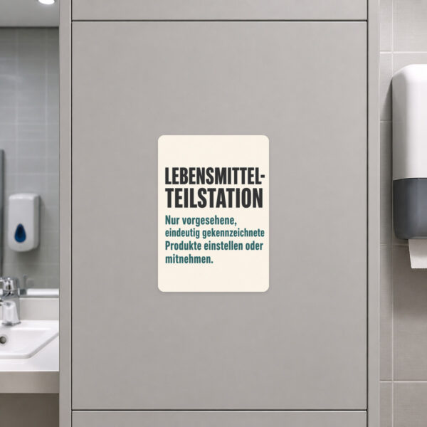 KI-generiertes Anwendungsbeispiel: Lebensmittel-Teilstation Aufkleber auf grauer Fläche mit Regal-Motiv und Hinweistext.