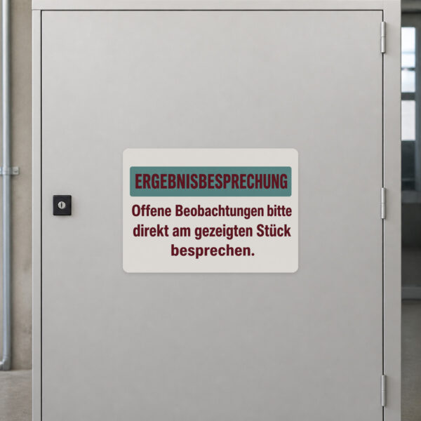 KI-generiertes Anwendungsbeispiel: Aufkleber Ergebnisbesprechung an grauer Fläche für direkte Beobachtungen am Stück.