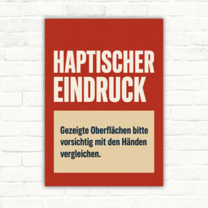 Haptischer Eindruck Schild mit dem Text „Gezeigte Oberflächen bitte vorsichtig mit den Händen vergleichen“ für Displays und Showrooms.