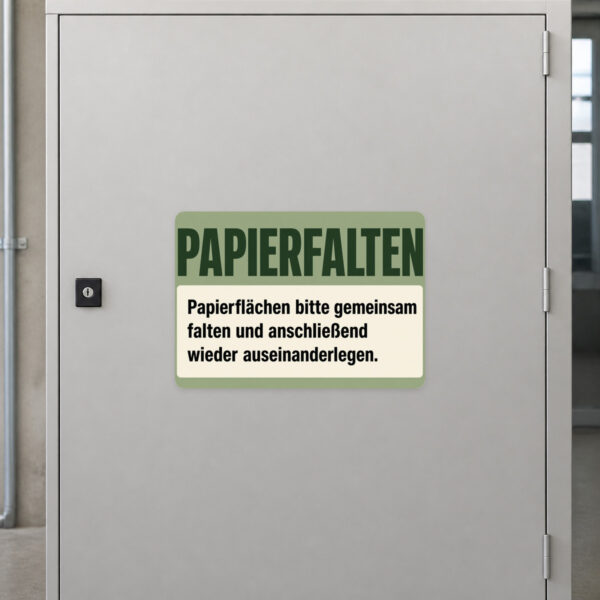 KI-generiertes Anwendungsbeispiel: Papierfalten Aufkleber auf grauem Untergrund mit cremefarbenem Motiv und Papierflächen.