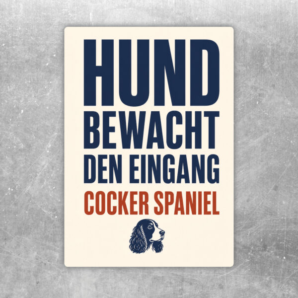 Aufkleber mit Cocker Spaniel vor Eingangstor und Text „Vorsicht! Hund bewacht den Eingang.“ in Braun und Beige.