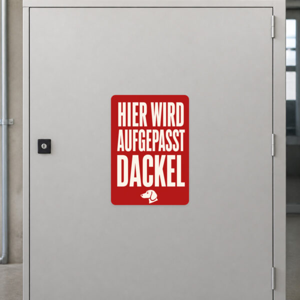 KI-generiertes Anwendungsbeispiel: Dackel Aufkleber „Vorsicht! Hier wird aufgepasst.“ an einer Eingangstür.