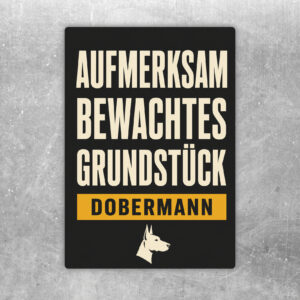 Aufkleber mit Dobermann, Text Achtung aufmerksam bewachtes Grundstück, schwarz-beige-braunes Warnmotiv.