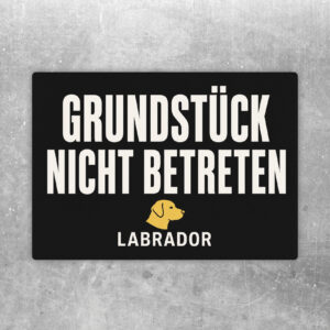 Querformatiger Aufkleber mit Text Warnung bitte Grundstück nicht betreten und schwarzem Labrador hinter Gartentor.