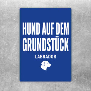 Hochformatiger Aufkleber mit Labrador hinter Zaun und Text Vorsicht Hund auf dem Grundstück in Türkis und Beige.