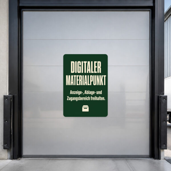KI-generiertes Anwendungsbeispiel: Digitaler Materialpunkt Aufkleber auf grauer Fläche mit Monitor, Kartons und Freihaltehinweis.