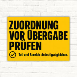 Schild mit Text „Zuordnung vor Übergabe prüfen“ und „Teil und Bereich eindeutig abgleichen“ im Technikdesign.