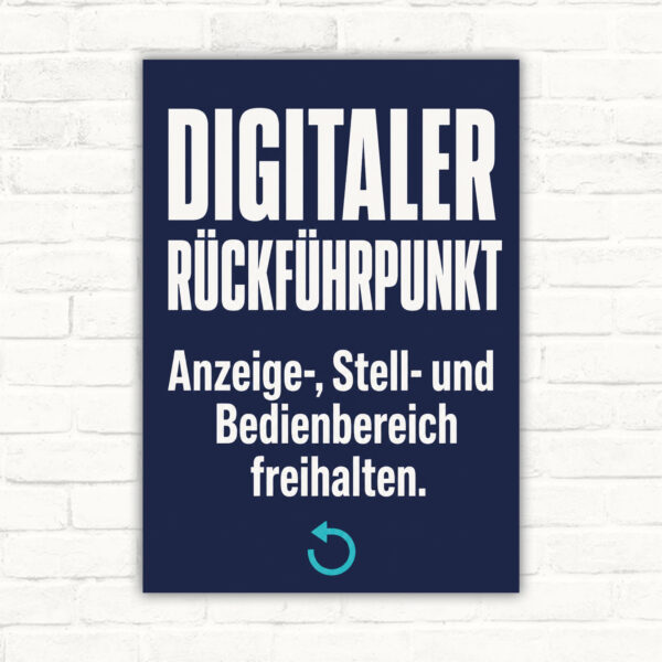 Schild „Digitaler Rückführpunkt“ mit Text „Anzeige-, Stell- und Bedienbereich freihalten“ und Transportboxen.