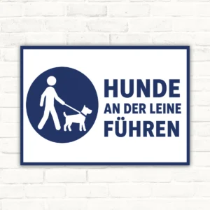 Hunde an der Leine führen Schild mit blauem Piktogramm, weißem Hintergrund und deutlichem Hinweistext für den Außenbereich.