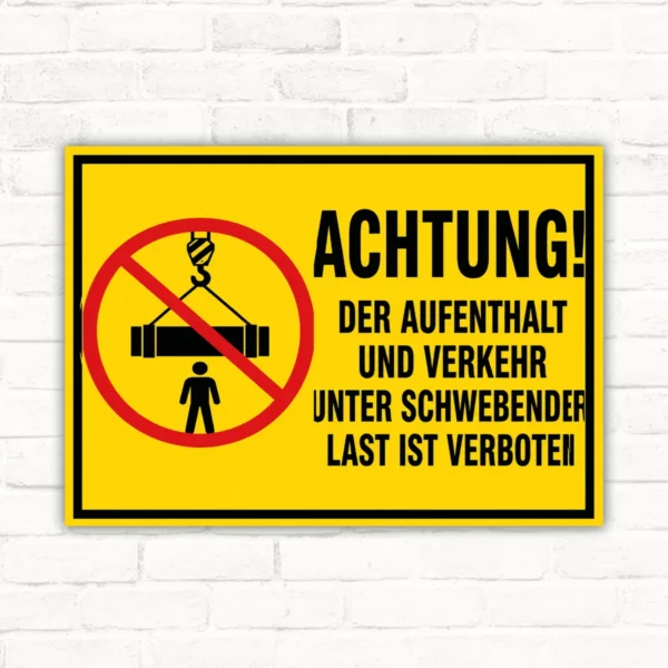 Verbotsschild mit gelbem Hintergrund: schwebende Last verboten, durchgestrichenes Lastsymbol und klarer Warntext im Querformat.