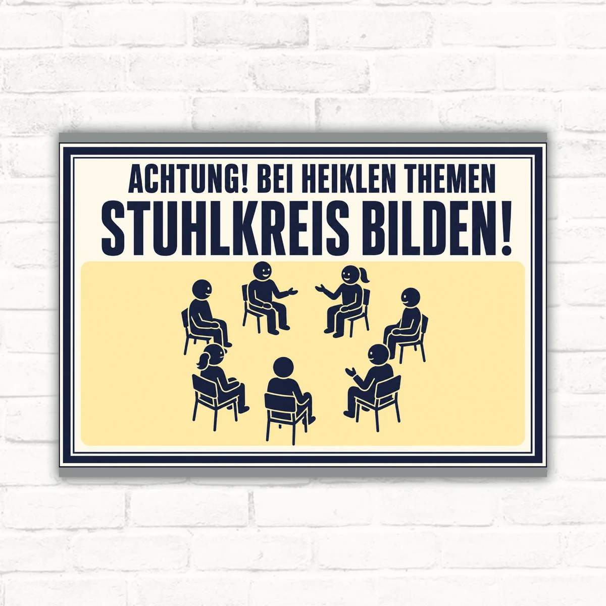 Bedrucktes Schild mit der Aufschrift „Achtung! Bei heiklen Themen Stuhlkreis bilden!“ und sitzenden Figuren im Kreis.