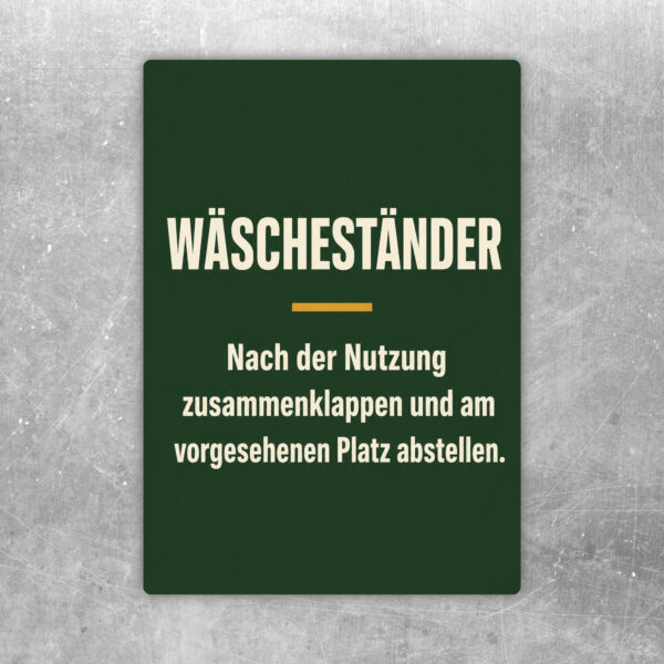 Wäscheständer zusammenklappen Aufkleber mit violettem Rahmen und Hinweis zum Abstellen am vorgesehenen Platz.