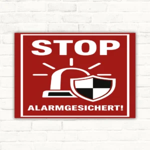 Rotes STOP Alarmgesichert Schild mit weißem Schriftzug und Schutzsymbol als Warnhinweis für gesicherte Bereiche.