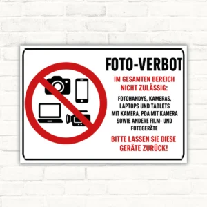 Foto-Verbot Schild mit Kamera-, Handy- und Gerätesymbol sowie Text „Im gesamten Bereich nicht zulässig“.