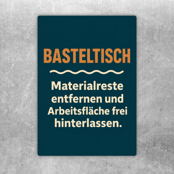 Basteltisch Aufkleber mit buntem Kreativmotiv und Hinweis, Materialreste zu entfernen und die Arbeitsfläche frei zu hinterlassen.