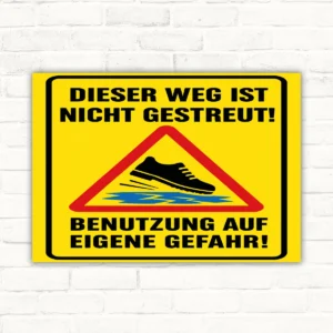 Warnschild mit Text „Dieser Weg ist nicht gestreut! Benutzung auf eigene Gefahr!“ und Rutschgefahr-Symbol im Hochformat.