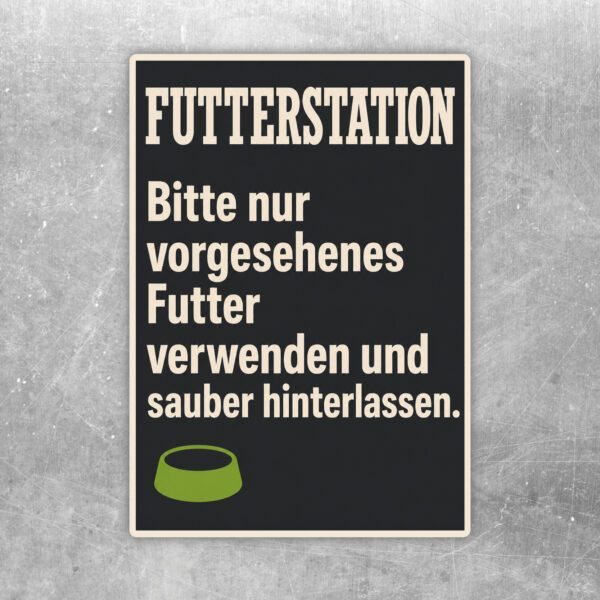 Futterstation Aufkleber mit orangefarbenem Rahmen, Näpfen und Hinweis zum vorgesehenen Futter und Sauberhalten.