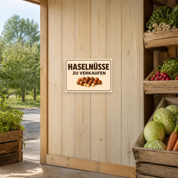 KI-generiertes Anwendungsbeispiel: Querformat-Schild mit Haselnüssen und dem Text „Haselnüsse zu verkaufen“ für Hofladen und Direktverkauf.