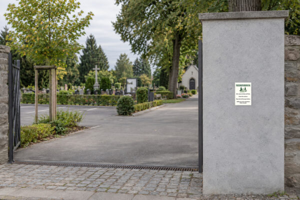 KI-generiertes Anwendungsbeispiel: Friedhofsordnung Aufkleber – Hochformat passend auf einem Friedhof angebracht.