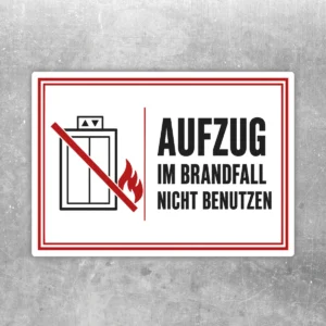 Aufzug im Brandfall nicht benutzen Aufkleber im Querformat mit rotem Rahmen, Flamme und durchgestrichenem Aufzugssymbol.