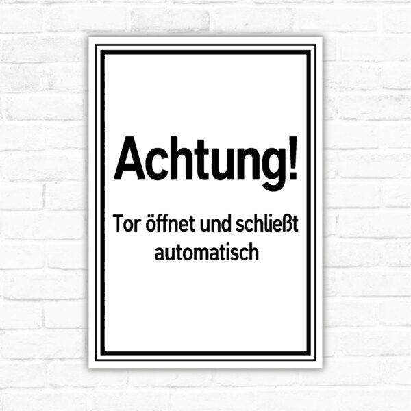 Hochformat-Schild mit Text „Achtung! Tor öffnet und schließt automatisch“ als Warnhinweis für Toranlagen.