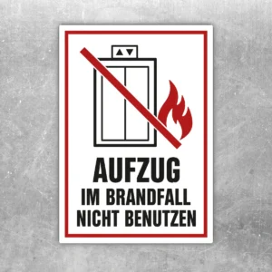 Aufzug im Brandfall nicht benutzen Aufkleber im Hochformat mit rotem Verbotsbalken, Flamme und schwarzem Text.