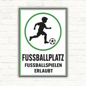 Fussballplatz Schild mit Spieler und Ball sowie dem Text „Fussballspielen erlaubt“ auf weiß-grünem Hintergrund.