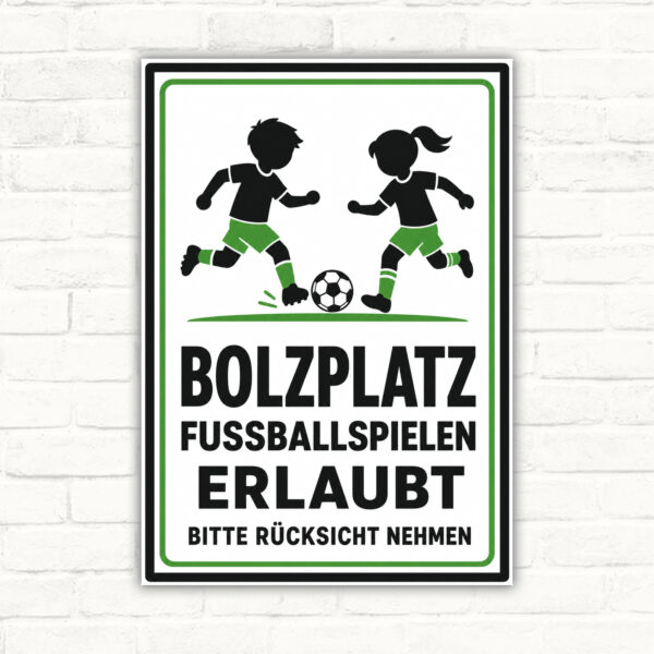 Bolzplatz-Schild mit spielenden Kindern und Text „Fussballspielen erlaubt, bitte Rücksicht nehmen“ als Hinweis zum Sportbereich.