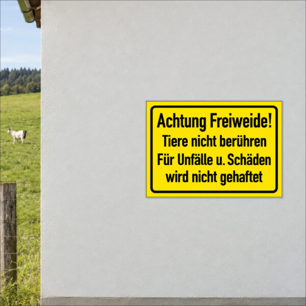Achtung Freiweide – Tiere nicht berühren als Schild im Querformat – beispielhaft an einer Stallwand angebracht